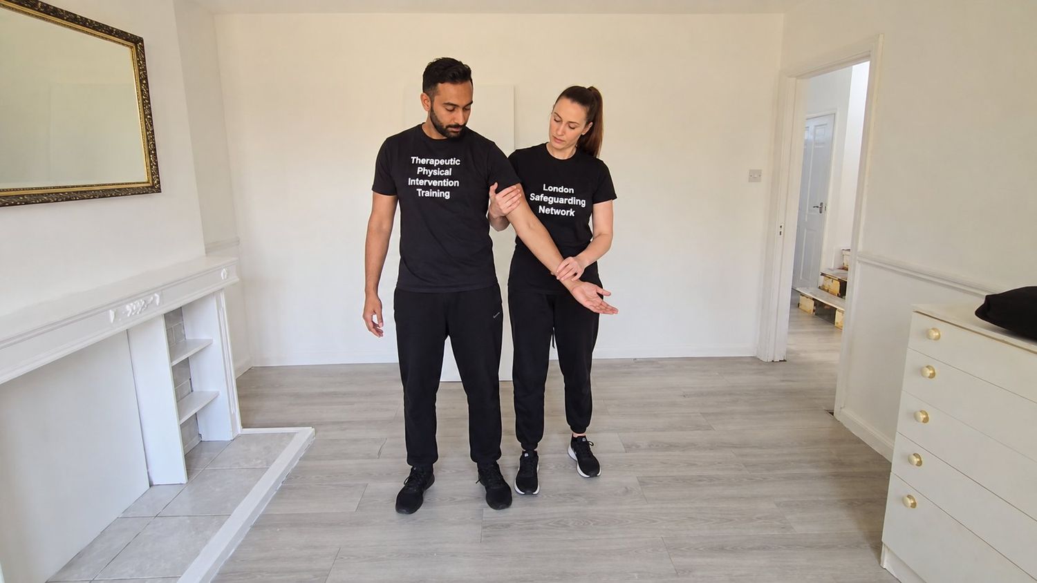 Guided escort technique demonstrated with controlled, supportive contact.