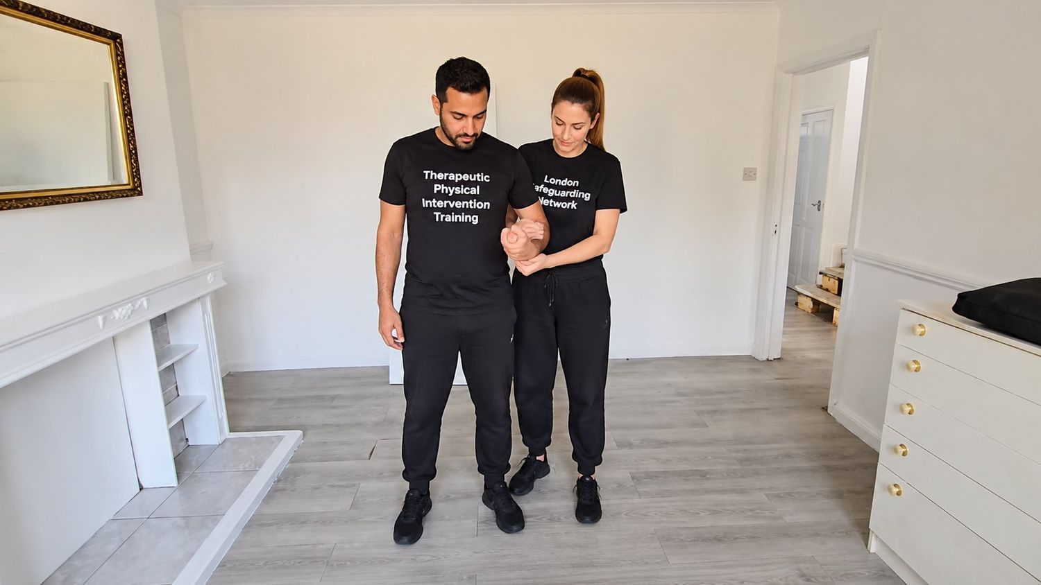 Therapeutic physical intervention training session — controlled, supportive technique.
