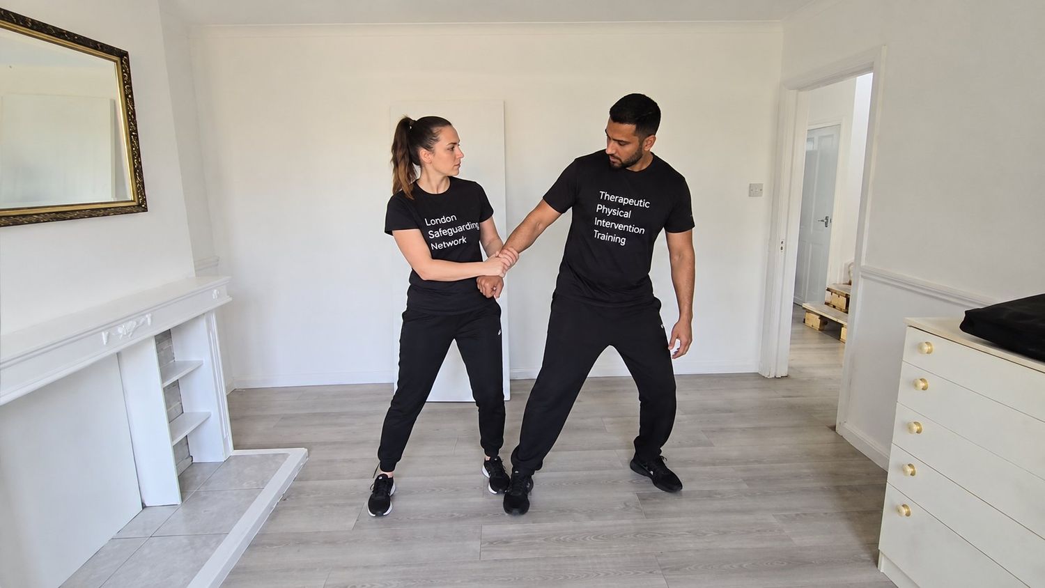 Therapeutic physical intervention training session — controlled, supportive technique.